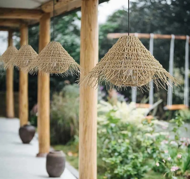 Natural rattan pendant lamp hanging on a covered patio ceiling
